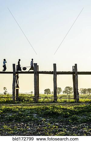 People walking on elevated wooden walkway in rural landscape View Large Photo Image Stock Photo - People walking on elevated wooden walkway in rural landscape. Fotosearch