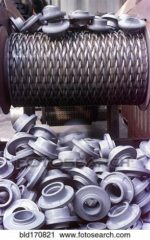 Stock Image - Plastic manufactured pieces on conveyor belt. Fotosearch