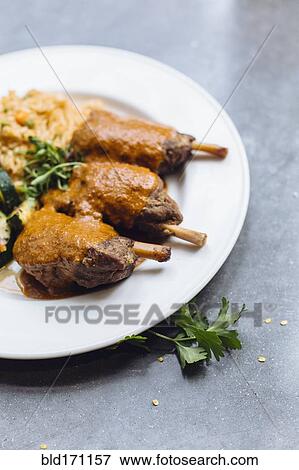 Stock Photo - Plate of meat and sauce with vegetables and rice. Fotosearch