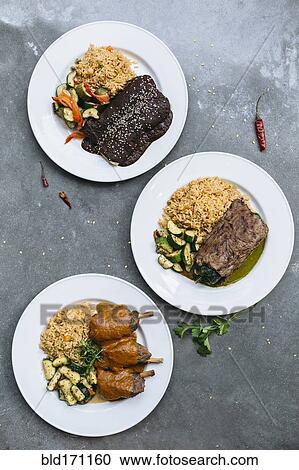 Stock Image - Plates of food with vegetables and rice. Fotosearch