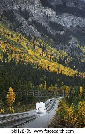 Stock Photography - R. V. driving on road through remote mountains. Fotosearch