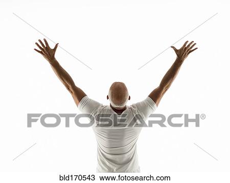 Stock Image - Rear view of older man cheering with arms raised. Fotosearch