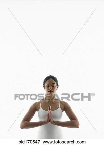 Stock Photo - Serene woman meditating with hands clasped. Fotosearch
