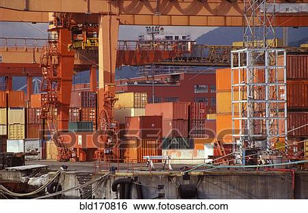 Stock Photograph - Shipping containers and cranes in industrial shipyard. Fotosearch