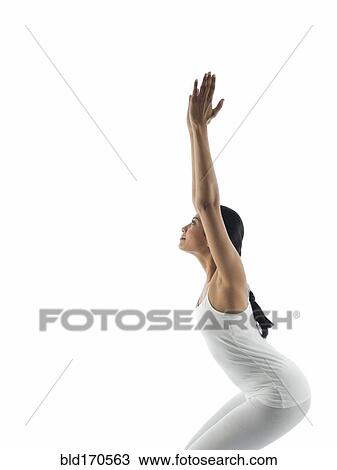 Stock Image - Side view of serene woman practicing yoga. Fotosearch