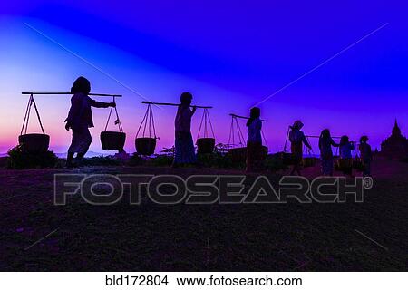 Silhouette of people carrying baskets under sunset sky View Large Photo Image Picture - Silhouette of people carrying baskets under sunset sky. Fotosearch