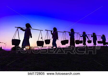 Silhouette of people carrying baskets under sunset sky View Large Photo Image Stock Photography - Silhouette of people carrying baskets under sunset sky. Fotosearch