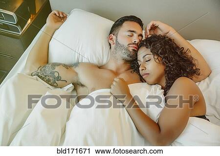 Stock Image - Sleeping couple hugging in bed. Fotosearch