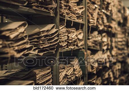Stock Image - Stacks of old newspapers in library archive. Fotosearch