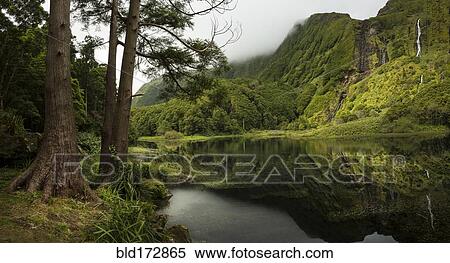 Stock Photography - Still lake under remote mountains. Fotosearch