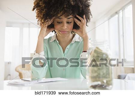 Stressed mixed race woman paying bills View Large Photo Image Stock Photo - Stressed mixed race woman paying bills. Fotosearch