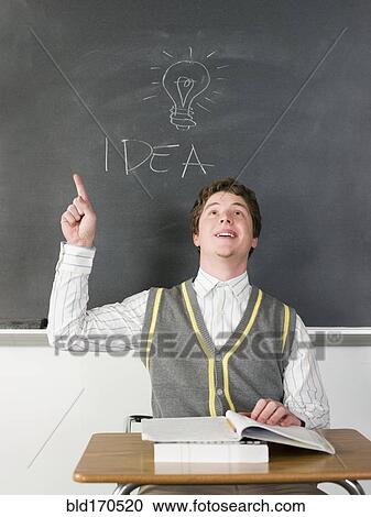 Stock Image - Student having idea under light bulb on chalkboard in classroom. Fotosearch