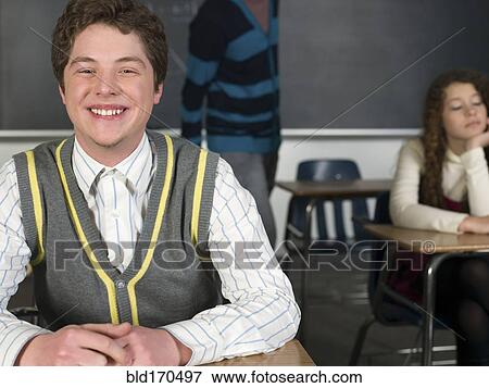 Stock Photo - Student smiling at desk in classroom. Fotosearch