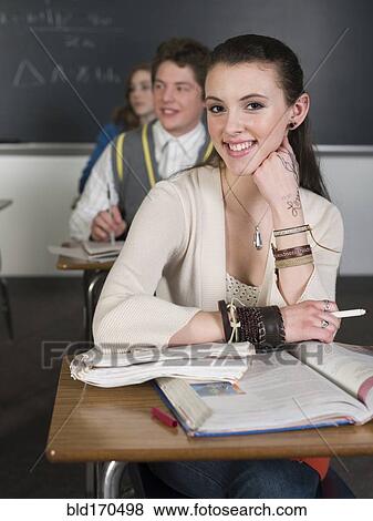 Student smiling at desk in classroom View Large Photo Image Stock Photo - Student smiling at desk in classroom. Fotosearch