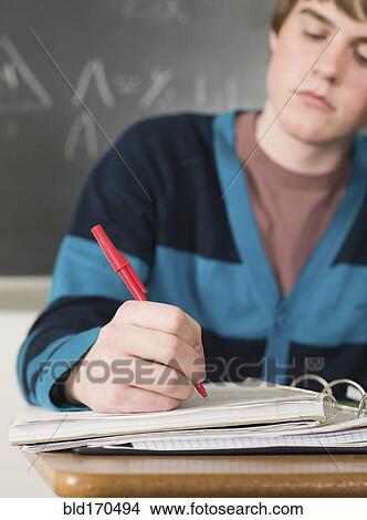 Student writing notes at desk in classroom View Large Photo Image Picture - Student writing notes at desk in classroom. Fotosearch