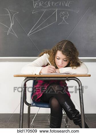 Student writing notes at desk in classroom View Large Photo Image Stock Photo - Student writing notes at desk in classroom. Fotosearch
