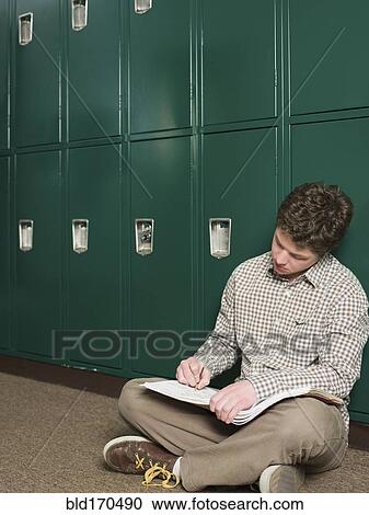 Student writing notes at locker in school hallway View Large Photo Image Stock Image - Student writing notes at locker in school hallway. Fotosearch