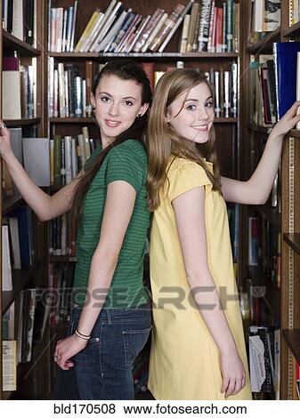 Stock Photo - Students choosing books in library. Fotosearch