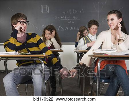 Students holding hands at desks in classroom View Large Photo Image Stock Image - Students holding hands at desks in classroom. Fotosearch