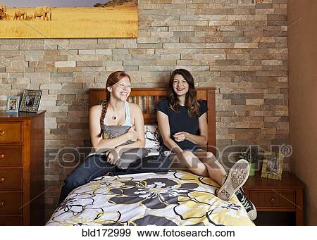 Students laughing on bed in dorm room View Large Photo Image Stock Photo - Students laughing on bed in dorm room. Fotosearch