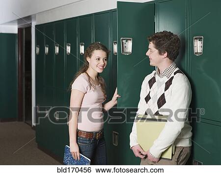 Stock Photograph - Students talking at locker in school hallway. Fotosearch