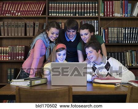 Stock Image - Students using laptop in library. Fotosearch