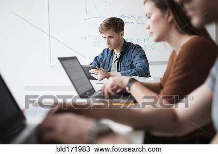 Stock Image - Students working in college classroom. Fotosearch