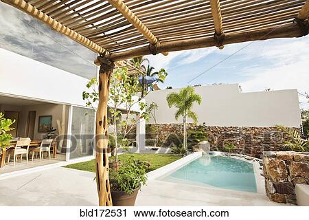 Stock Image - Swimming pool and canopy in backyard. Fotosearch