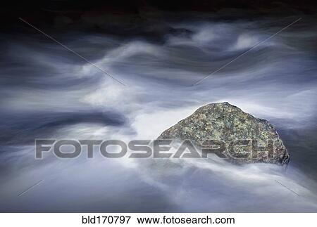 Stock Photo - Time lapse view of fog clouds over rock. Fotosearch
