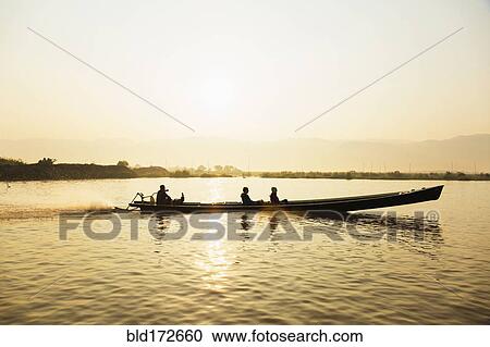 Tourists riding in canoe on rural lake View Large Photo Image Stock Image - Tourists riding in canoe on rural lake. Fotosearch