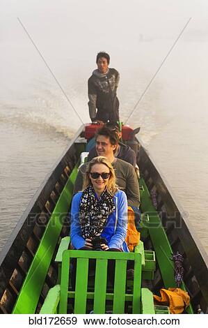Stock Photo - Tourists riding in canoe on rural lake. Fotosearch