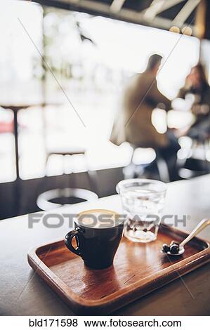 Stock Photo - Tray of coffee, coffee beans and water in cafe. Fotosearch