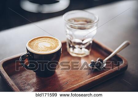 Stock Photo - Tray of coffee, coffee beans and water in cafe. Fotosearch
