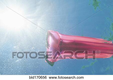 Underwater view of woman sunbathing on raft in ocean View Large Photo Image Stock Photograph - Underwater view of woman sunbathing on raft in ocean. Fotosearch
