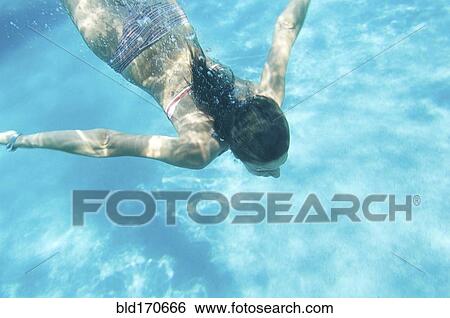 Underwater view of woman swimming in ocean View Large Photo Image Stock Photograph - Underwater view of woman swimming in ocean. Fotosearch