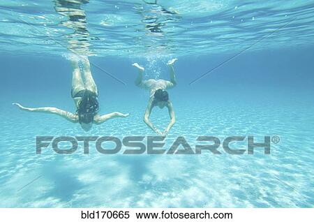 Underwater view of women swimming in ocean View Large Photo Image Stock Photography - Underwater view of women swimming in ocean. Fotosearch