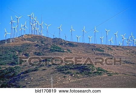 Wind turbines on hilltop in remote landscape View Large Photo Image Stock Photo - Wind turbines on hilltop in remote landscape. Fotosearch