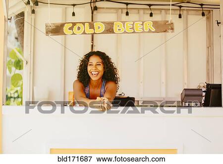 Stock Photo - Woman leaning in beach shack. Fotosearch