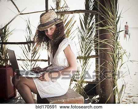 Woman using laptop in beach hut View Large Photo Image Stock Image - Woman using laptop in beach hut. Fotosearch