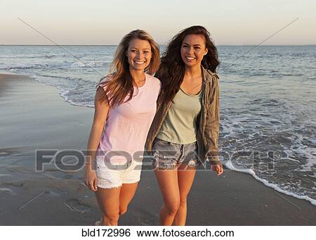 Stock Photograph - Women walking on beach. Fotosearch