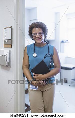 Stock Image - African American doctor holding digital tablet. Fotosearch