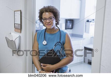 Stock Photograph - African American doctor holding digital tablet. Fotosearch