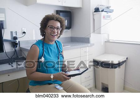 Stock Image - African American doctor using digital tablet. Fotosearch