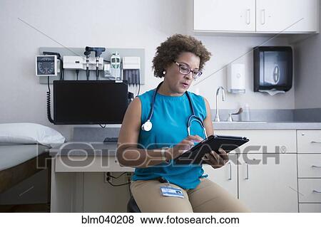 Stock Photo - African American doctor using digital tablet. Fotosearch
