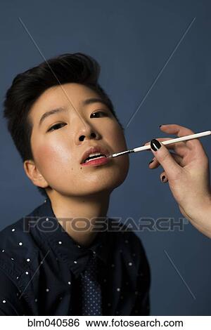 Stock Photograph - Androgynous woman having makeup applied. Fotosearch