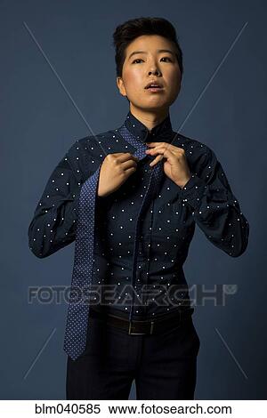 Androgynous woman tying tie View Large Photo Image Stock Photography - Androgynous woman tying tie. Fotosearch