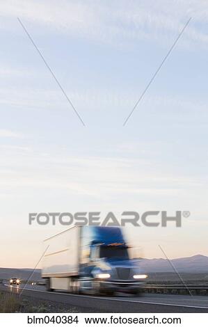 Blurred view of truck driving on remote highway View Large Photo Image Picture - Blurred view of truck driving on remote highway. Fotosearch