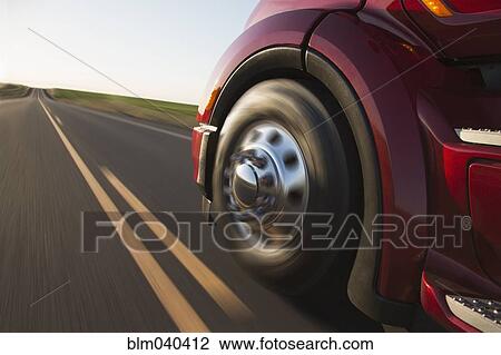Stock Image - Blurred view of truck driving on remote highway. Fotosearch
