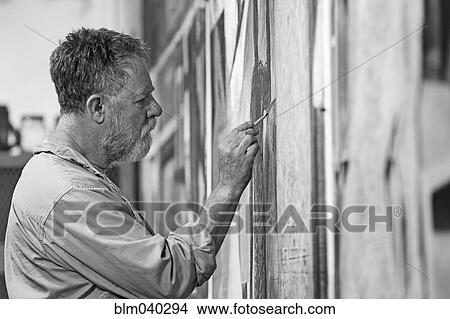 Picture - Caucasian artist painting in studio. Fotosearch