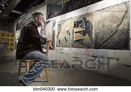 Stock Image - Caucasian artist sitting in studio. Fotosearch